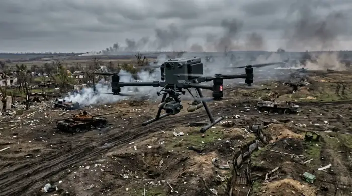 Drone militaire autonome survolant un champ de bataille, illustrant l'intelligence artificielle appliquée aux armes.